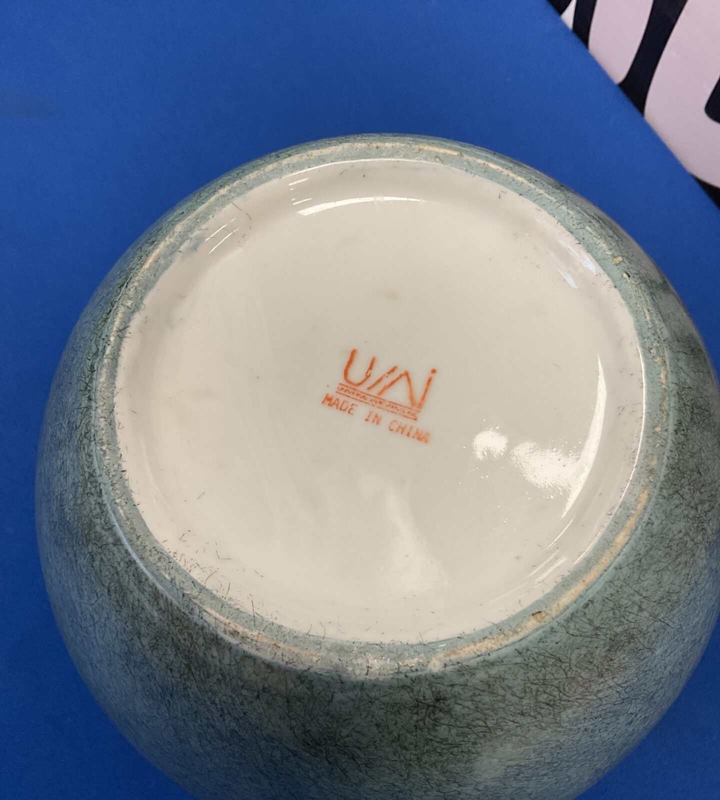 Side view of a green ceramic Chinese lidded pot.