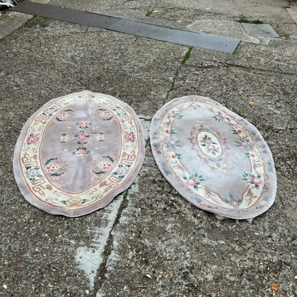 Pair of vintage Chinese oval rugs with floral designs.