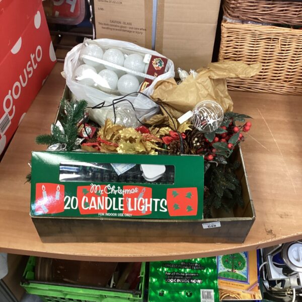 Box of Christmas decorations including a wreath and lights.