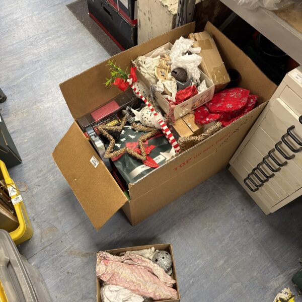 Large lot of colourful Christmas decorations in a cardboard box.