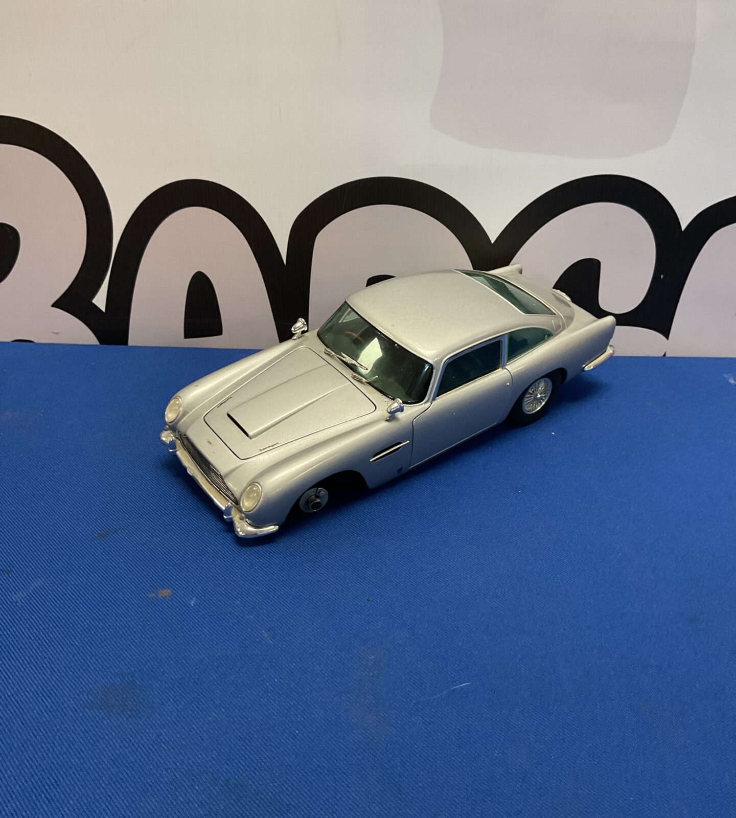Side view of silver Chrono Aston Martin DB5 model car.