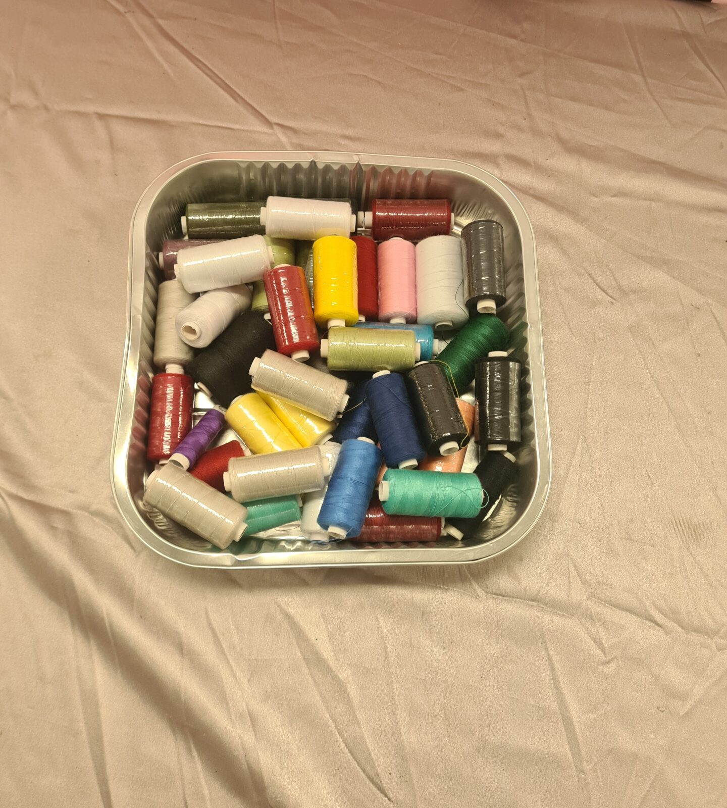 Colourful sewing thread lot on spools for crafting projects.