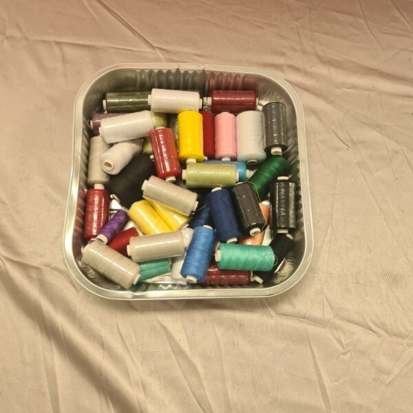 Colourful sewing thread lot on spools for crafting projects.