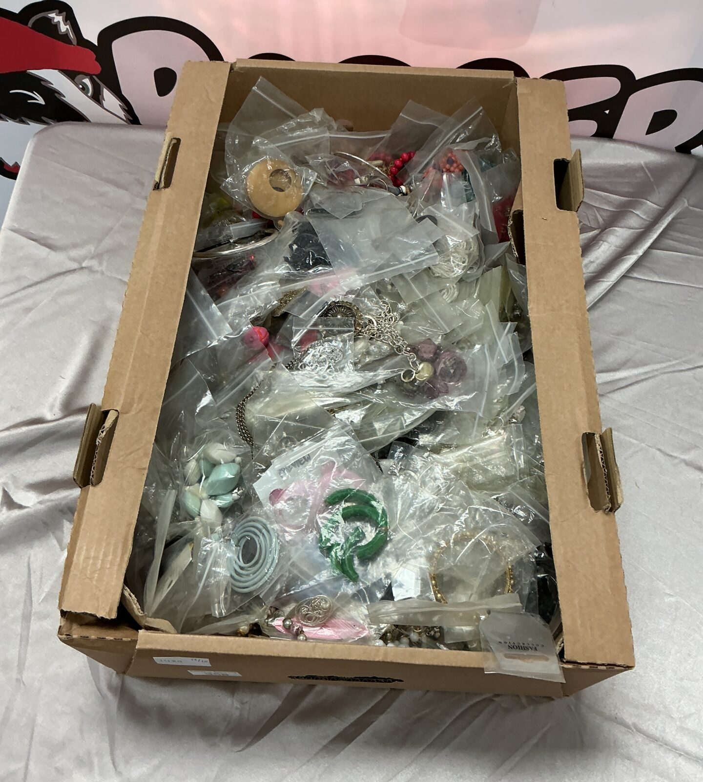 Close-up view of colourful costume jewellery in a cardboard box.