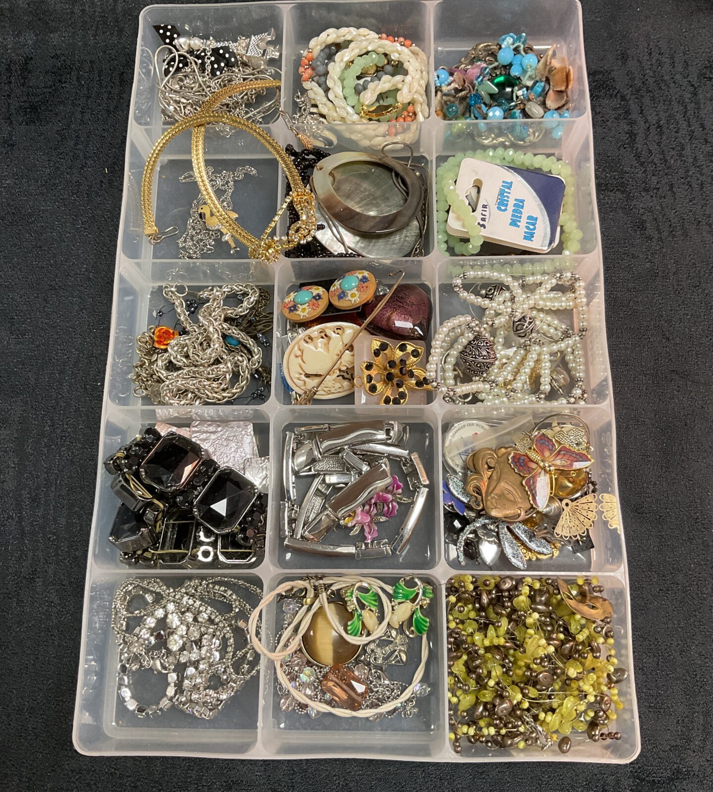 Tray of mixed costume jewellery with necklaces, earrings, and brooches.