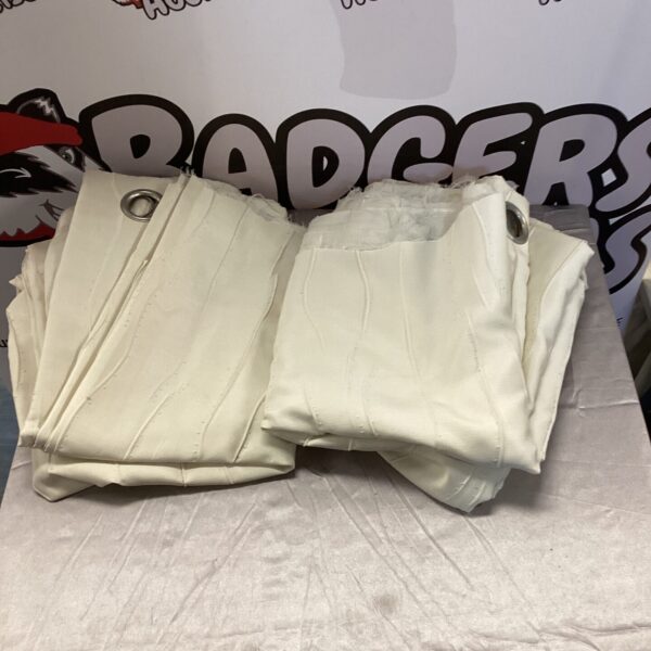 Pair of cream curtains presented for auction.