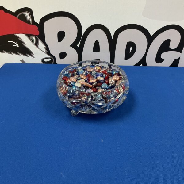 Colourful glass beads inside a sparkling crystal bowl.