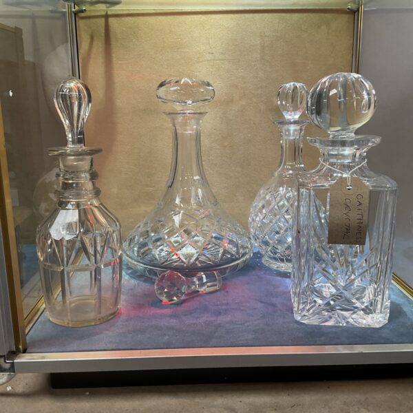 Four vintage crystal decanters displayed together, including Georgian and Caithness styles.