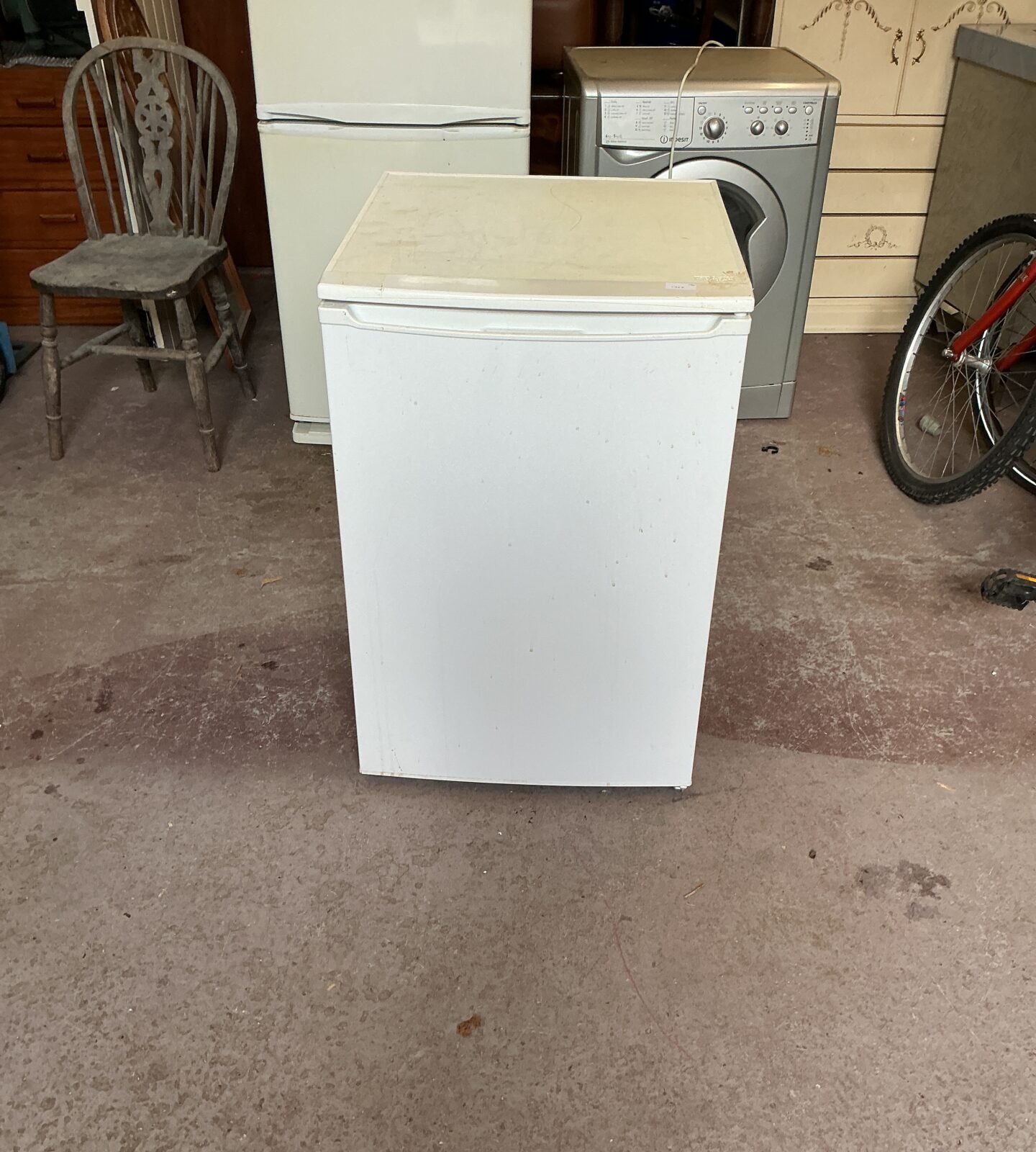 Side view of a white Curry’s Essentials fridge with the door open.