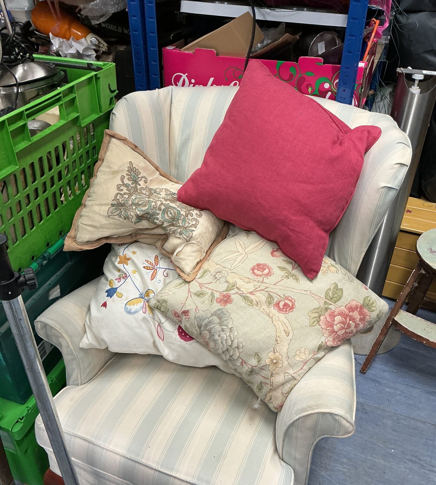 Vintage floral cushions arranged on a comfortable armchair.