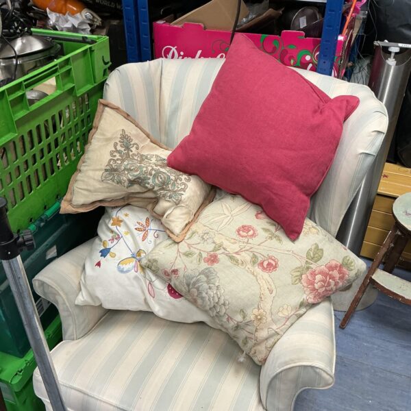 Vintage floral cushions arranged on a comfortable armchair.