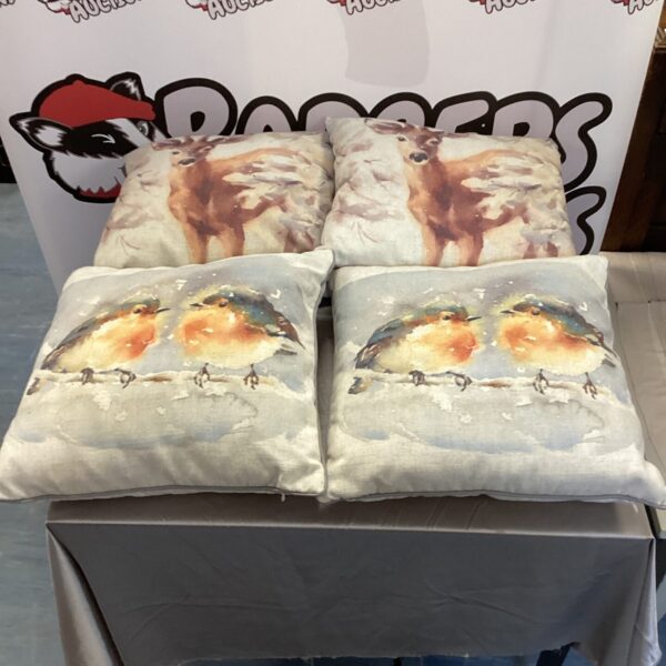 Set of four deer and robin cushions for home decor.