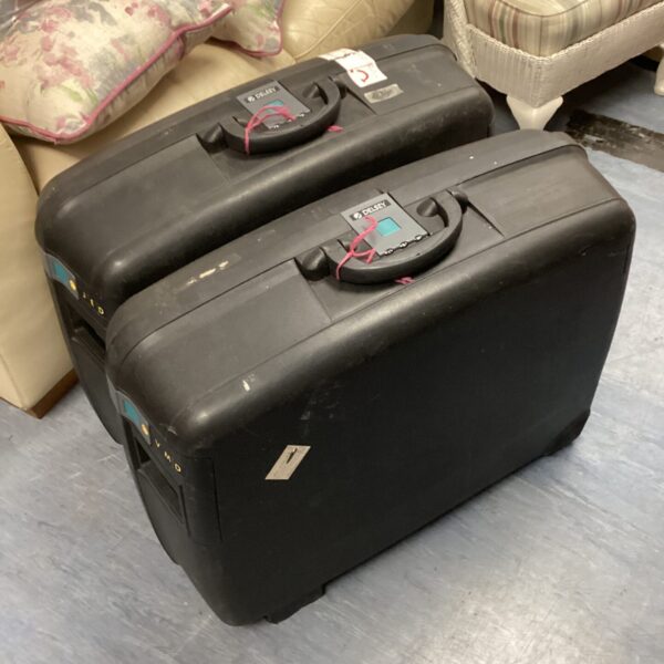 Two black Delsey suitcases stacked, showing signs of wear.