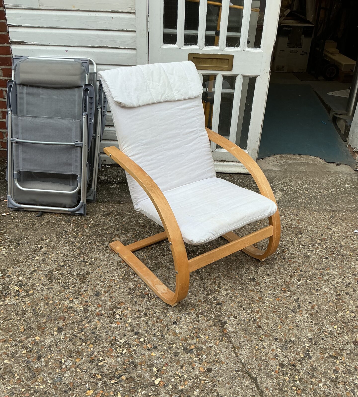 White upholstered designer easy chair with wooden frame.