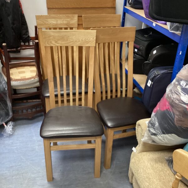 Vintage dining chair set with wooden frames and leatherette seats.