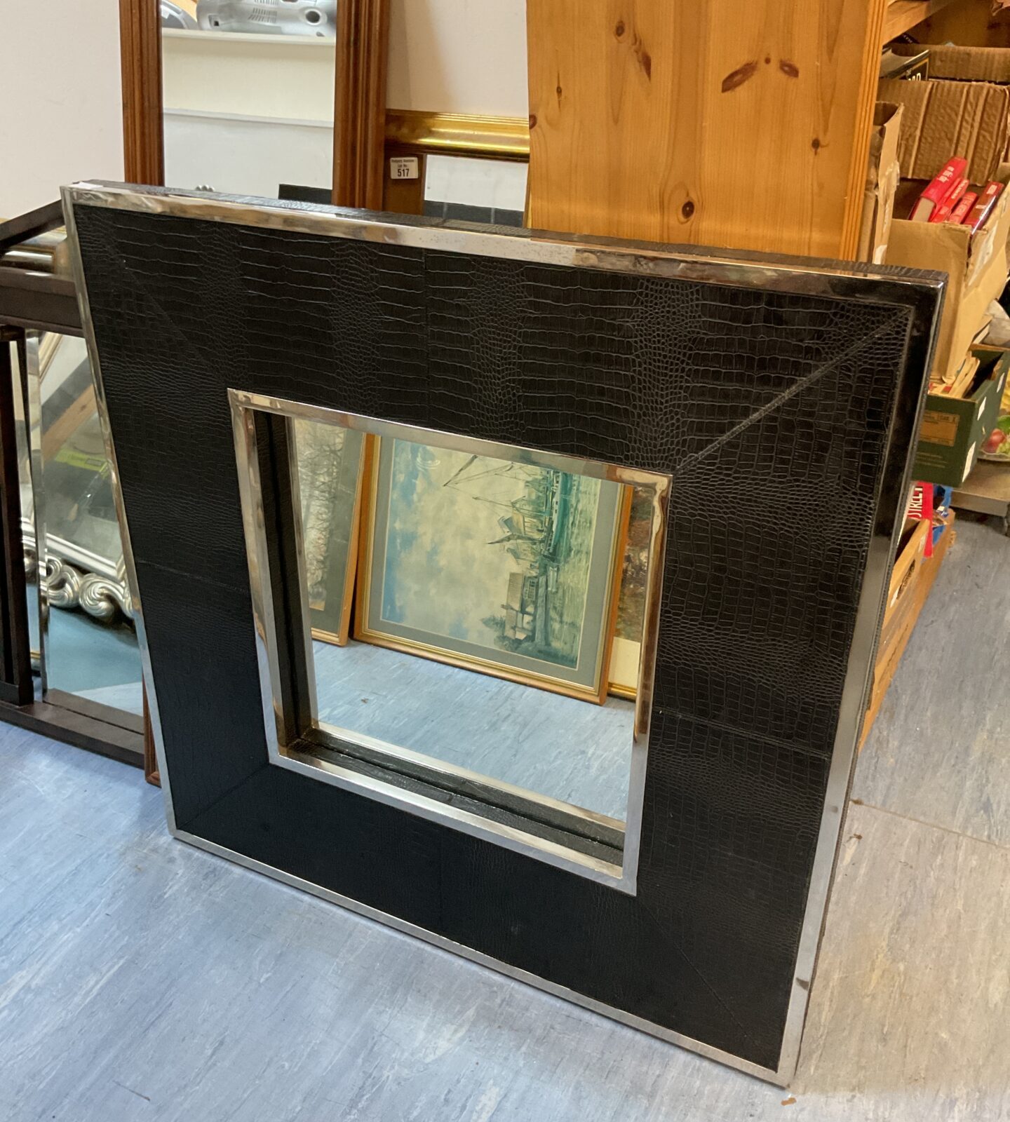 Large square faux leather and chrome framed mirror for modern home decor.