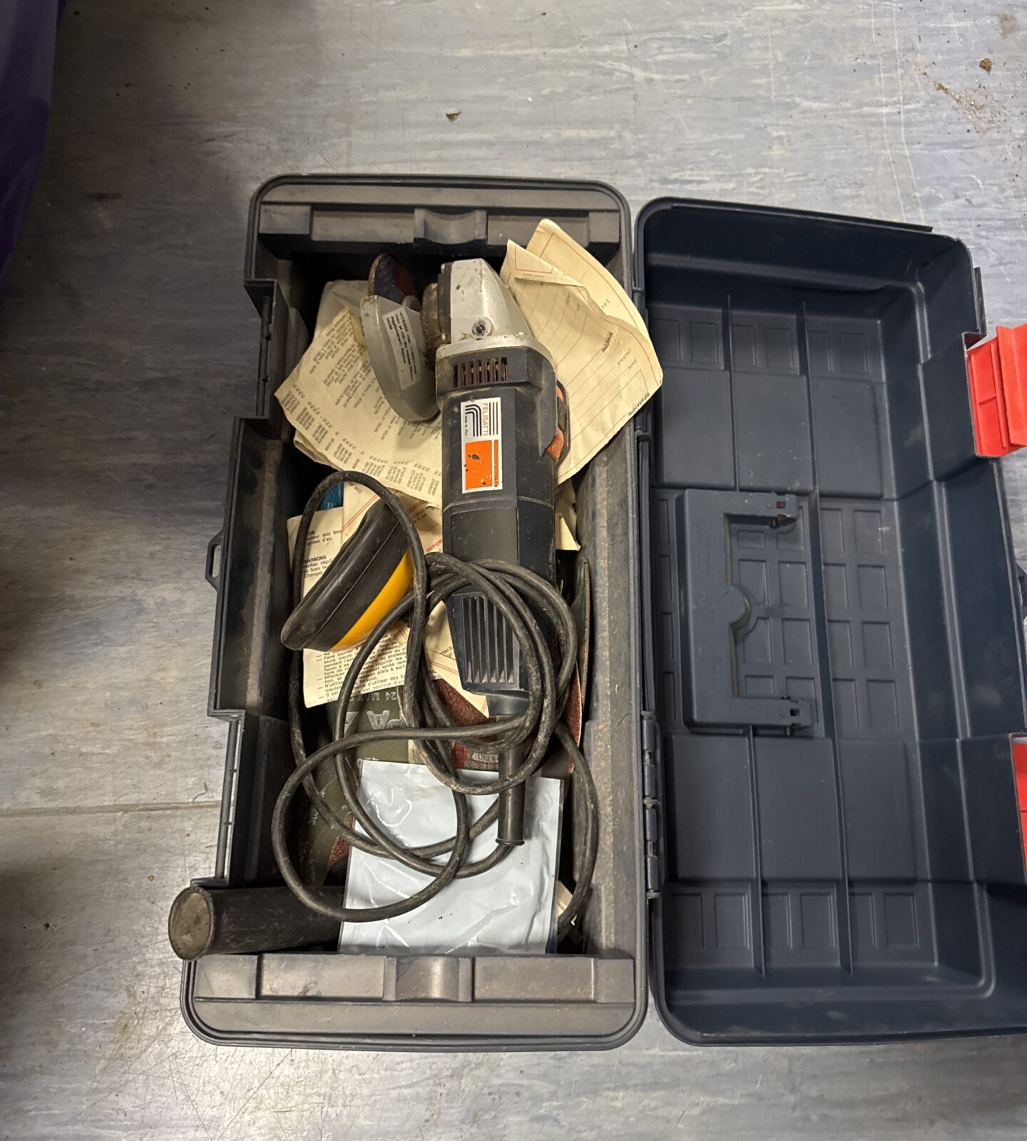Vintage Felsetti angle grinder inside a plastic toolbox.