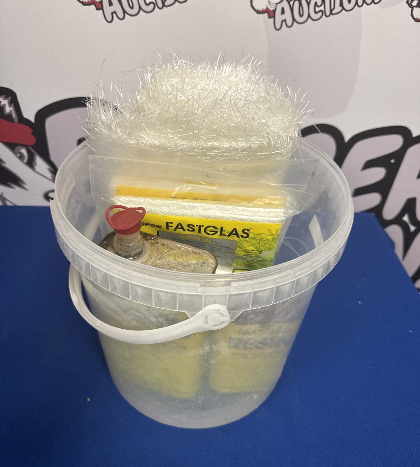 Fibreglass resin kit with bucket and resin tins.