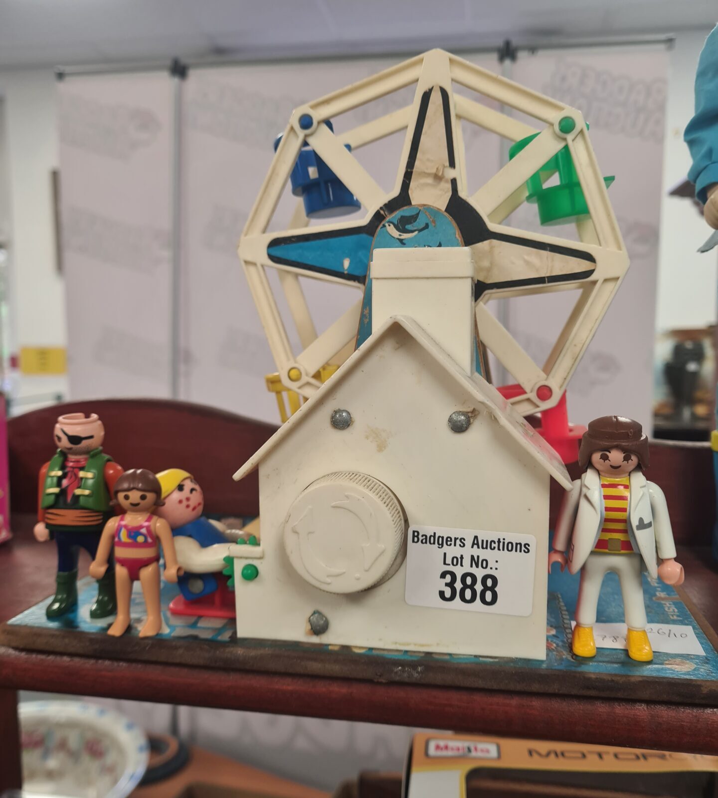 Vintage Fisher-Price musical Ferris wheel with Playmobil figures.