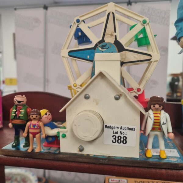 Vintage Fisher-Price musical Ferris wheel with Playmobil figures.
