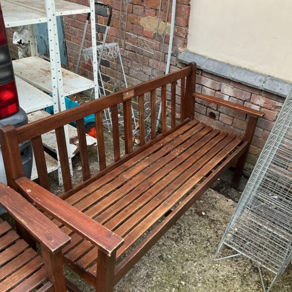 Five foot wooden garden bench in a garden setting.