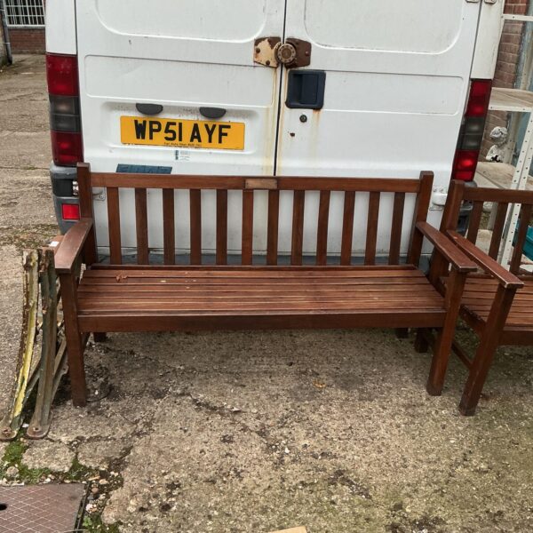 Five foot wooden garden bench in a garden setting.