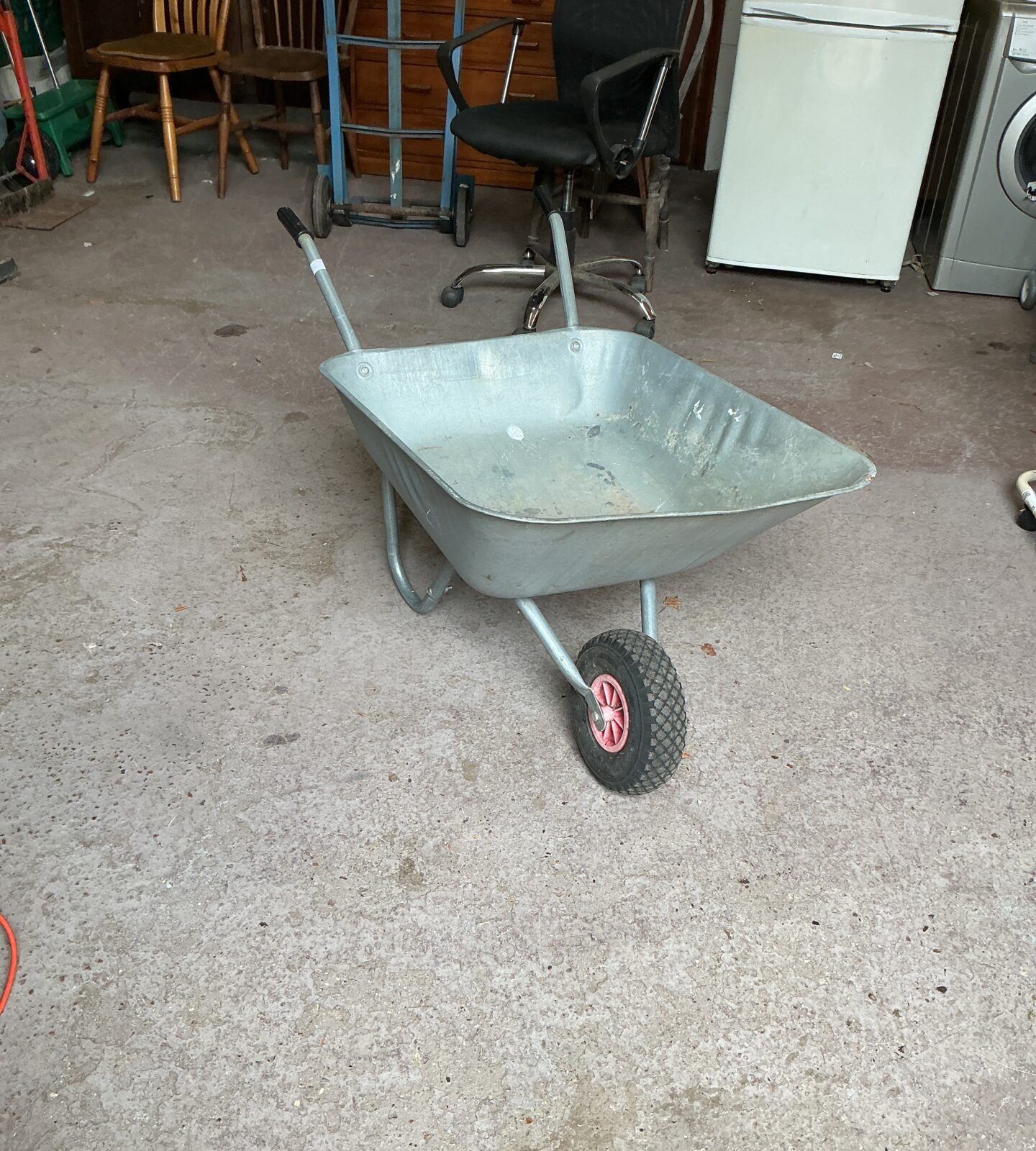 Galvanised garden wheelbarrow with a single wheel for outdoor use.
