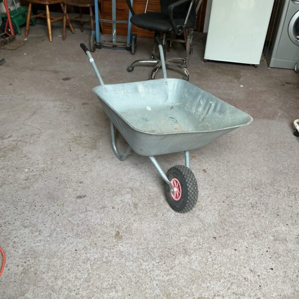 Galvanised garden wheelbarrow with a single wheel for outdoor use.