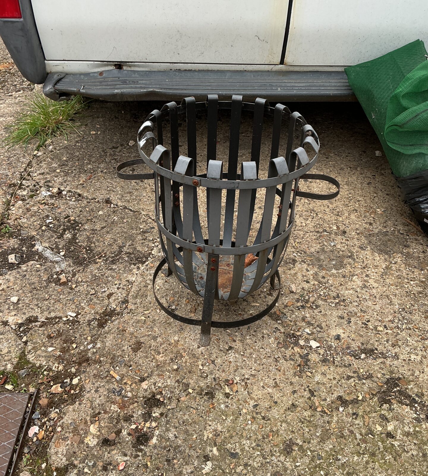 Rustic metal garden fire basket for outdoor heating.