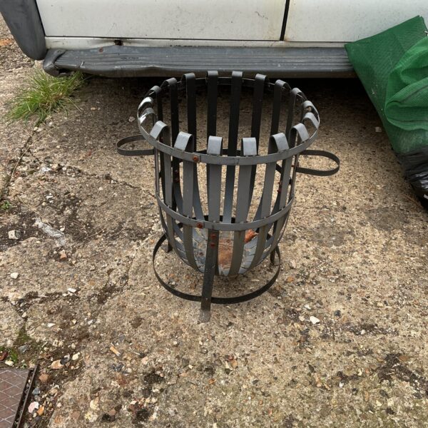 Rustic metal garden fire basket for outdoor heating.