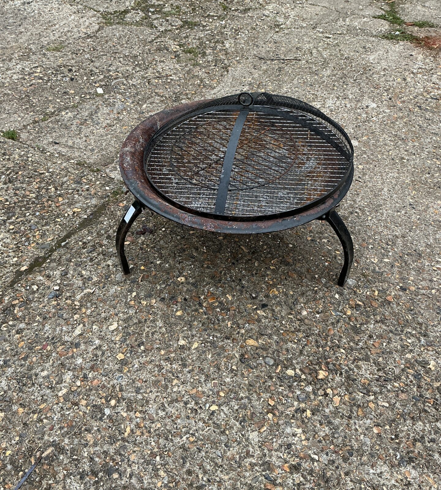 Rustic metal garden fire basket for outdoor heating.