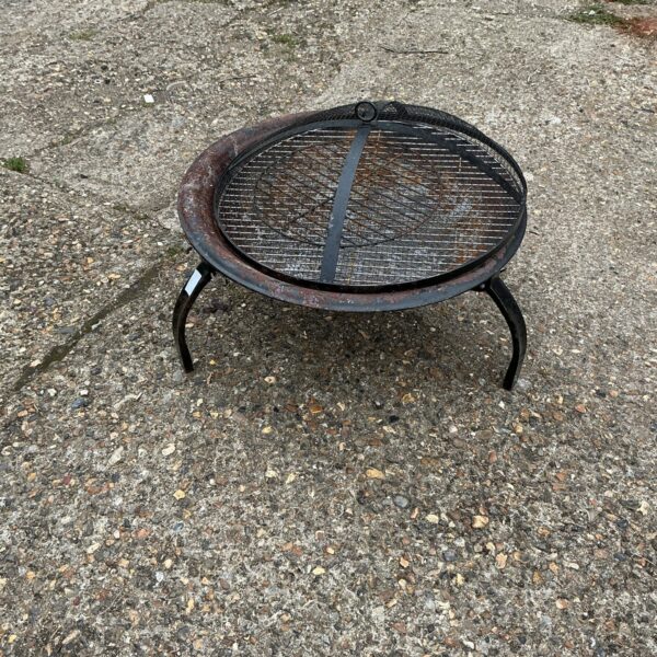 Rustic metal garden fire basket for outdoor heating.