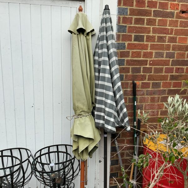 Green and white checked garden patio umbrella with stand.