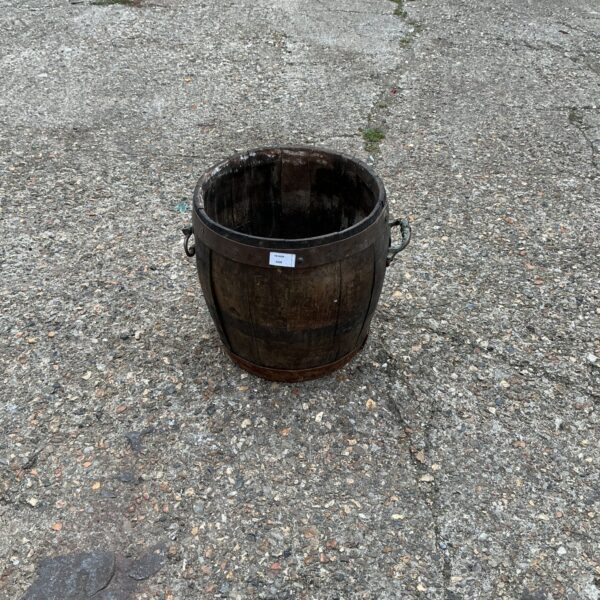 Rustic wooden garden planter barrel for outdoor use.