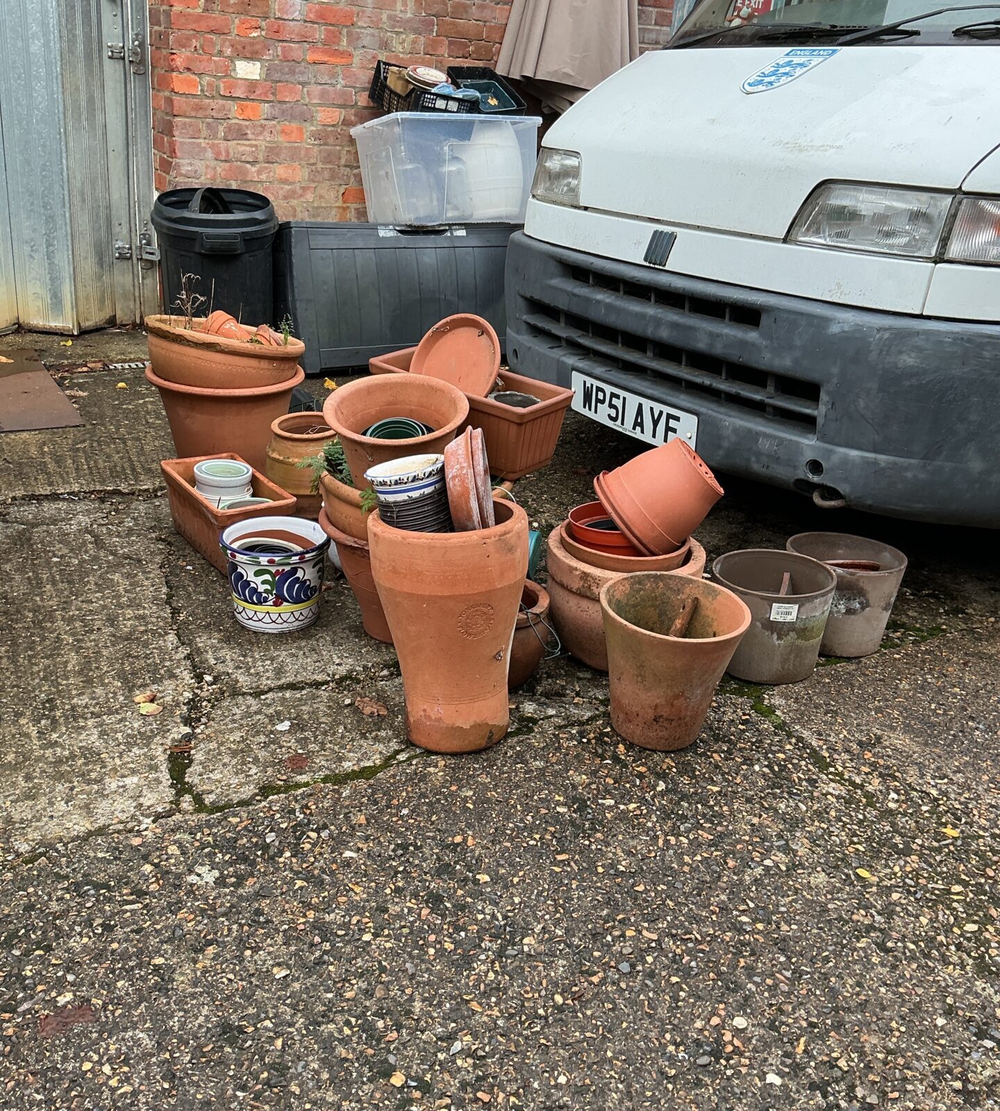 Assorted terracotta garden pots and planters in a garden setting.