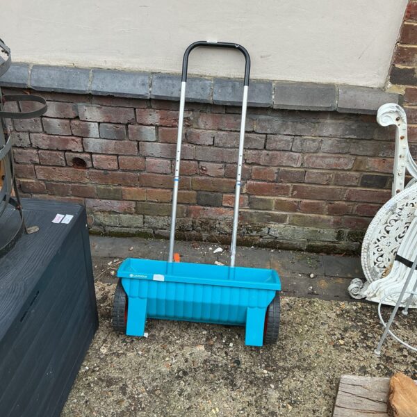 Blue Gardena lawn feeder for spreading seeds and fertilizer.