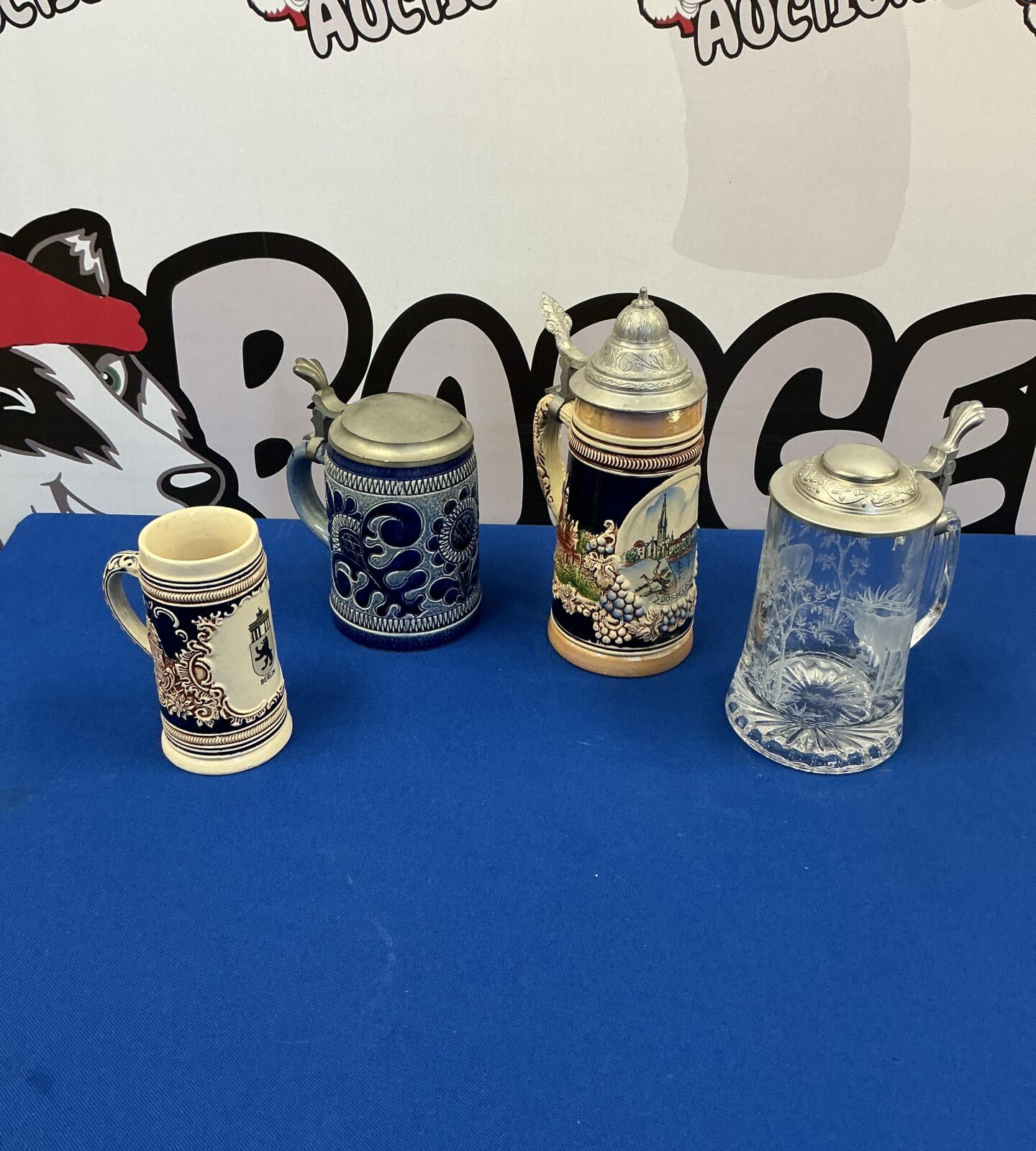 Four vintage German beer steins displayed together.