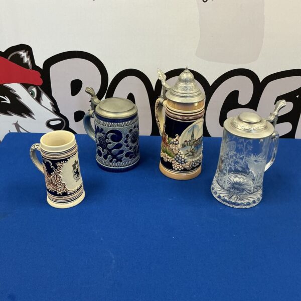 Four vintage German beer steins displayed together.