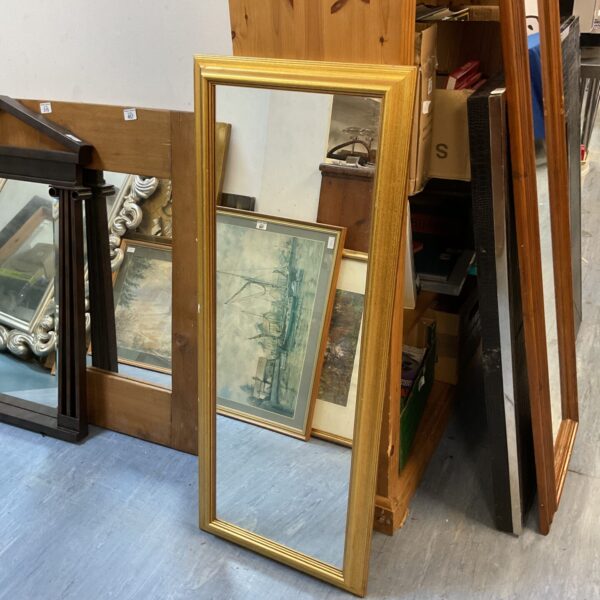 Ornate gilt framed bedroom mirror with a vintage aesthetic.
