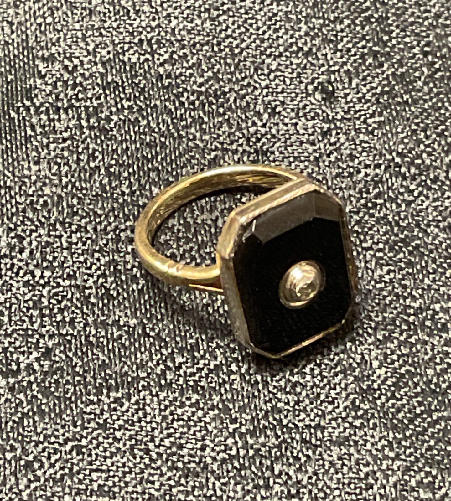 Gold ring with black stone, close-up view.