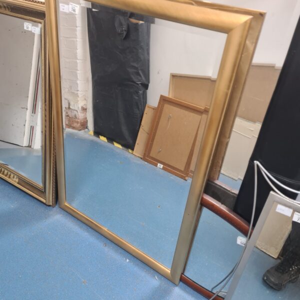 Elegant gold framed mirror with a vintage aesthetic.