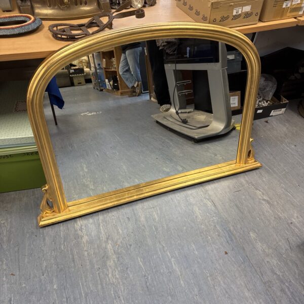 Antique gold overmantle mirror with ornate detailing.