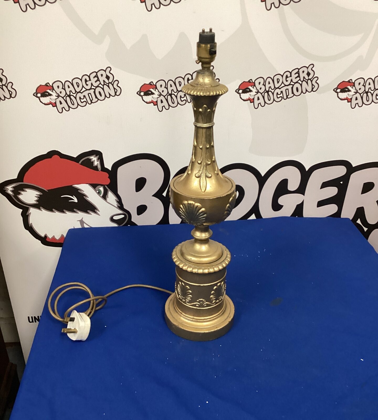 Vintage gold table lamp with decorative sculpted base.