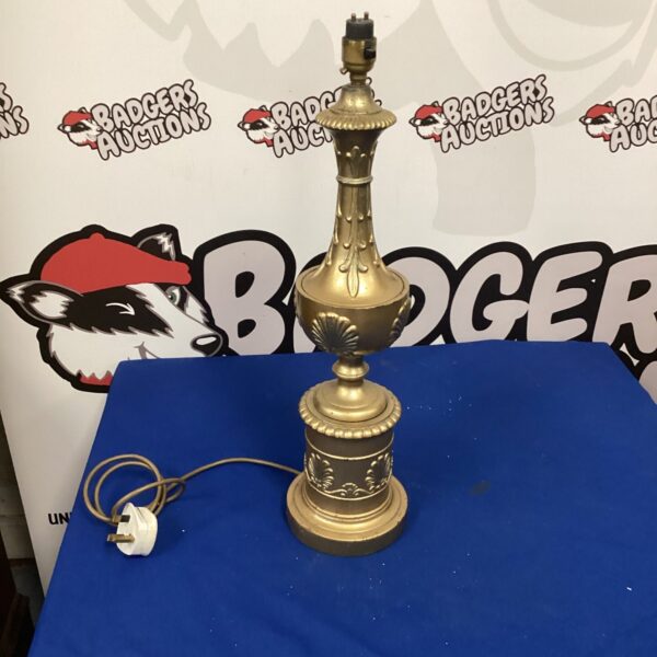 Vintage gold table lamp with decorative sculpted base.