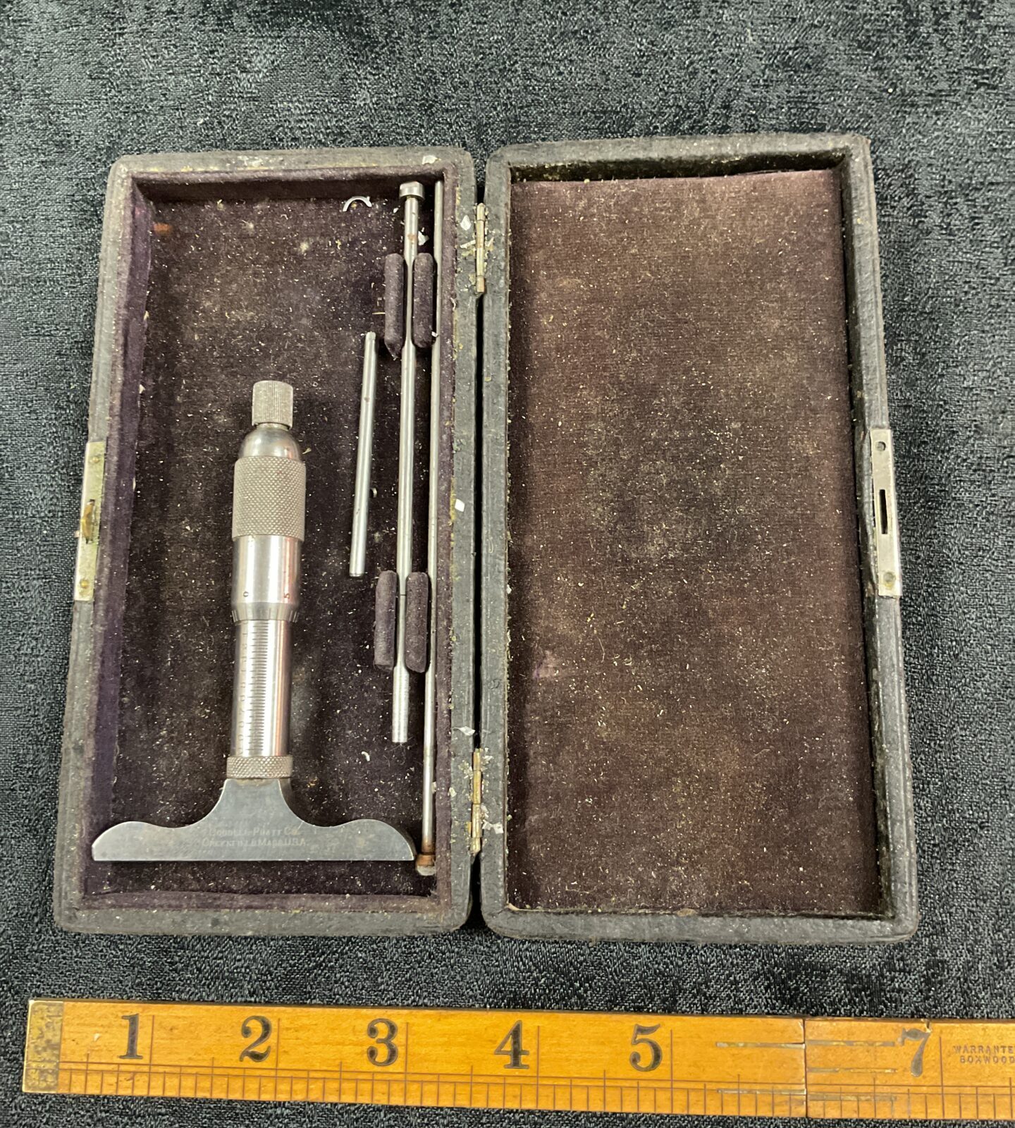 Open wooden case displaying a vintage Goodell Pratt depth micrometer.