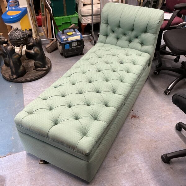 Green tufted daybed with storage, side view.