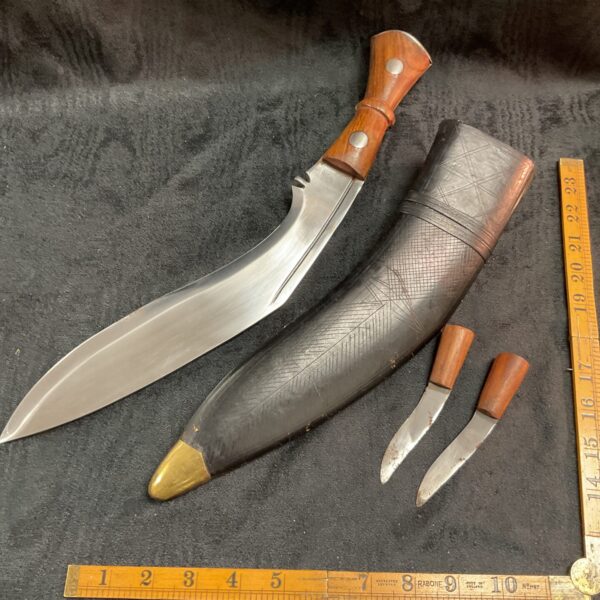 Vintage Gurkha Khukuri knife with wooden handle and scabbard.