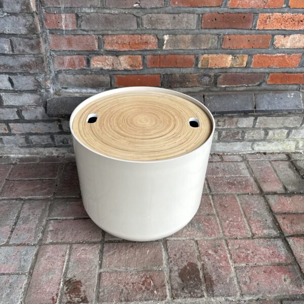 White Habitat drum side table against brick wall.