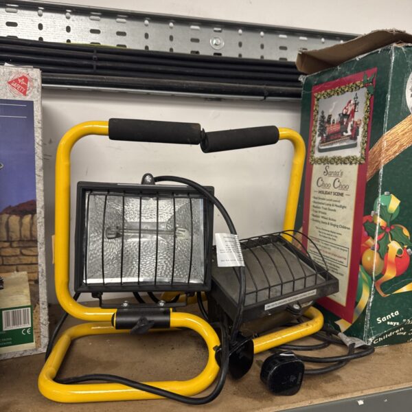 Pair of halogen site lights with metal cages for jobsite illumination.