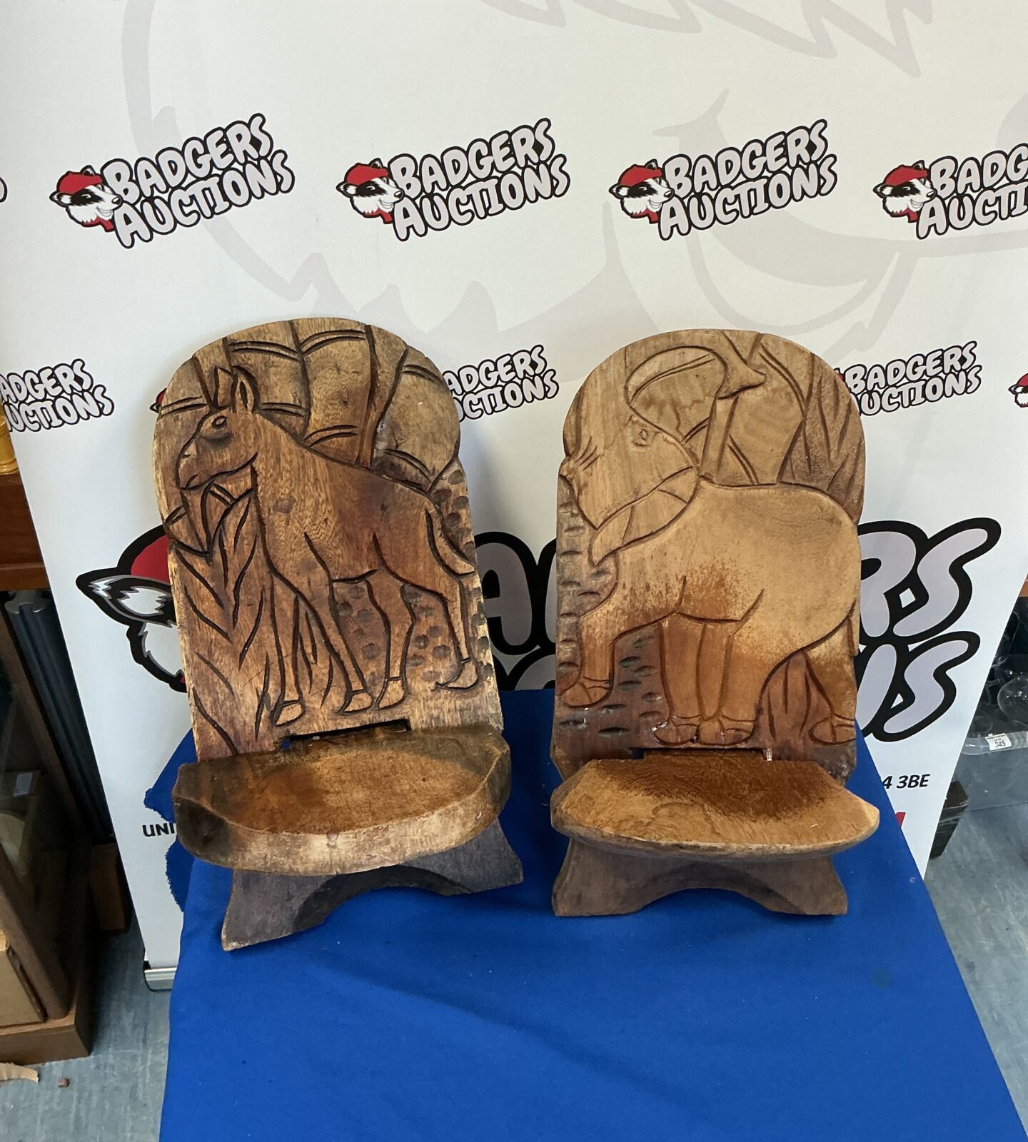 Pair of vintage hand-carved child’s seats with face details.